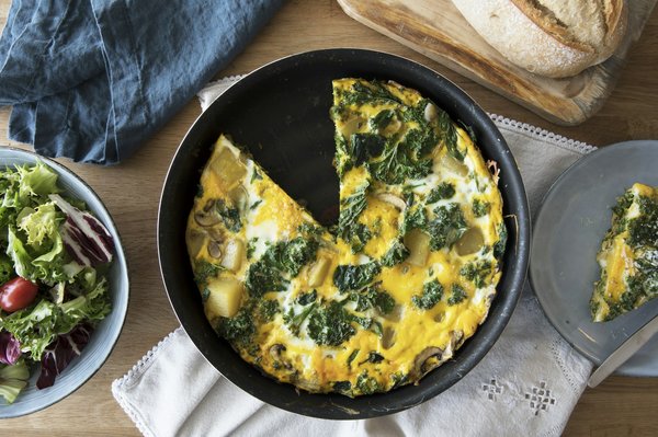 Quali sono i passaggi per una frittata di zucchine con fiori ed erbe aromatiche?